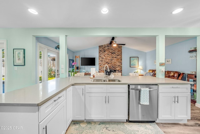 kitchen with sink, white cabinetry, stainless steel dishwasher, and vaulted ceiling with beams