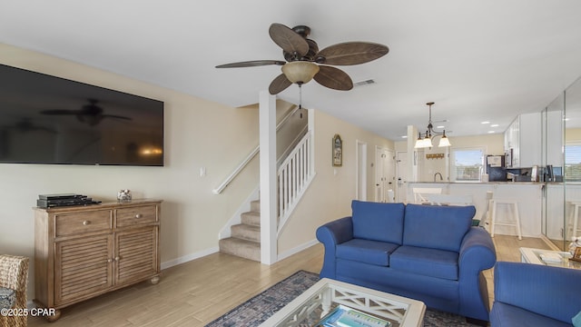 living room featuring ceiling fan, sink, and light hardwood / wood-style flooring