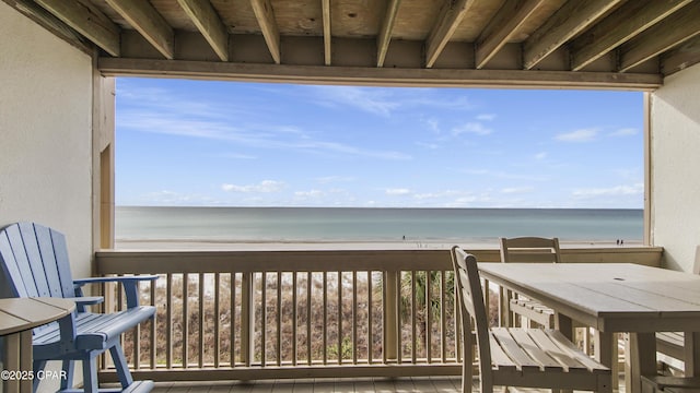 balcony with a water view and a beach view