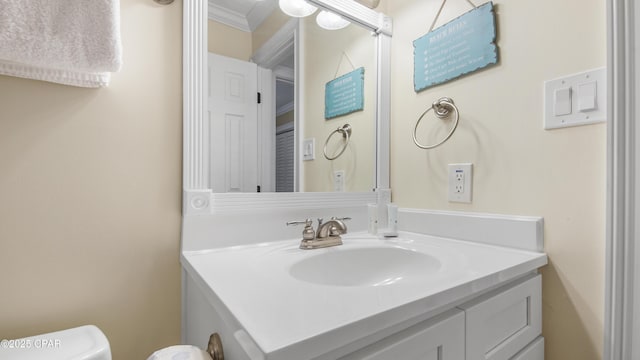 bathroom with ornamental molding, toilet, and vanity