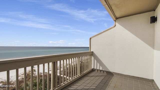 balcony with a water view and a view of the beach