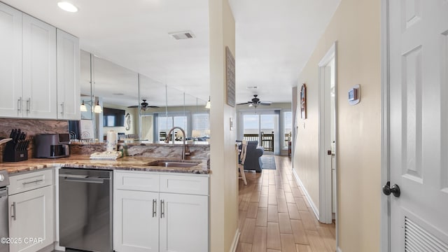 kitchen with white cabinetry, stainless steel dishwasher, kitchen peninsula, and sink