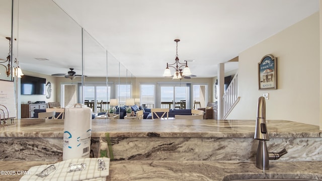 kitchen featuring sink, decorative light fixtures, and ceiling fan with notable chandelier