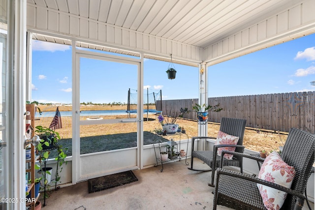 sunroom / solarium featuring a water view