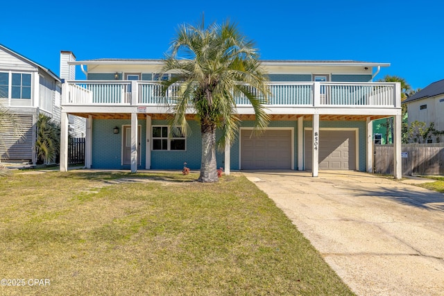 raised beach house featuring a front lawn and a garage