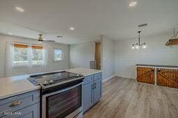 kitchen featuring light wood-type flooring, stainless steel range with electric cooktop, and pendant lighting