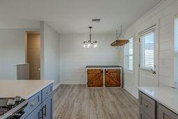 kitchen with pendant lighting, light hardwood / wood-style flooring, and a notable chandelier