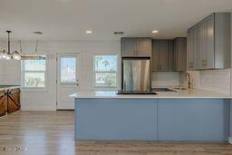 kitchen featuring kitchen peninsula, gray cabinetry, and pendant lighting