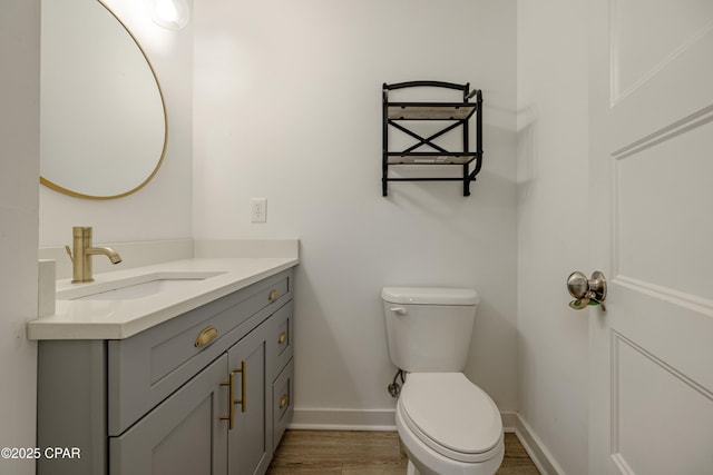 bathroom featuring toilet, hardwood / wood-style flooring, and vanity