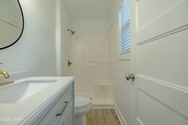 bathroom featuring walk in shower, vanity, toilet, and hardwood / wood-style flooring