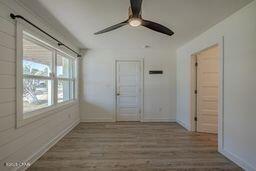 interior space with ceiling fan and wood-type flooring