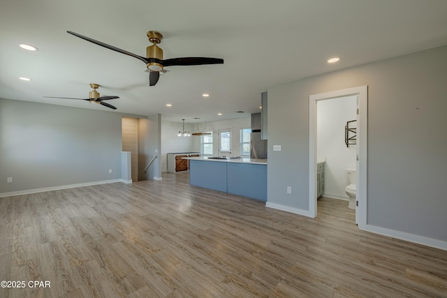 unfurnished living room with ceiling fan and light hardwood / wood-style flooring