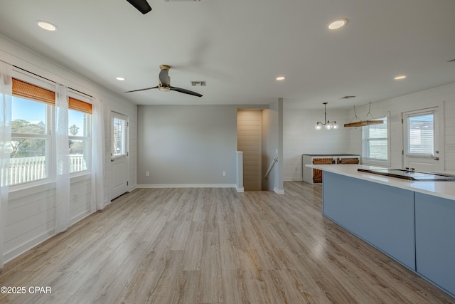 unfurnished living room with ceiling fan, a wealth of natural light, and light hardwood / wood-style floors