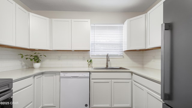 kitchen with dishwasher, sink, stainless steel fridge, white cabinets, and backsplash