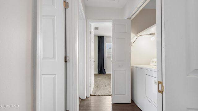 hallway with washer / clothes dryer and dark carpet