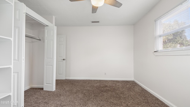 unfurnished bedroom with ceiling fan, carpet flooring, and a closet