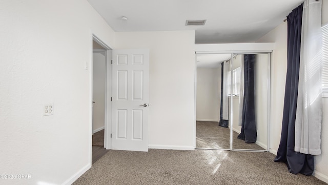 unfurnished bedroom featuring carpet floors and a closet