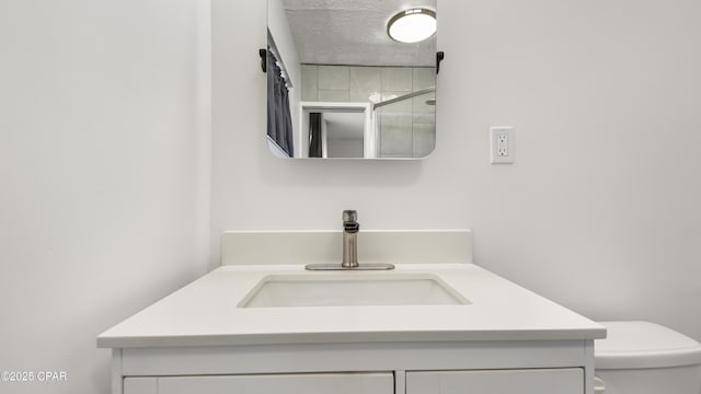 bathroom featuring vanity, walk in shower, and toilet