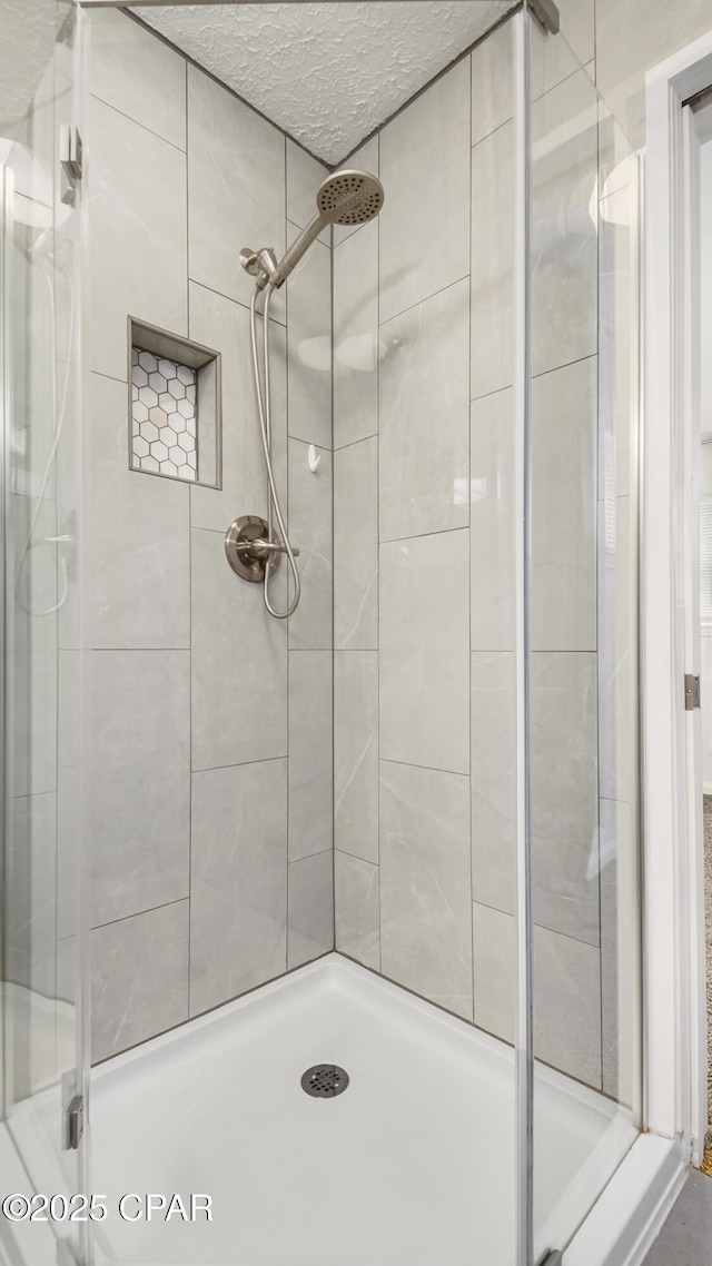 bathroom with a textured ceiling and walk in shower