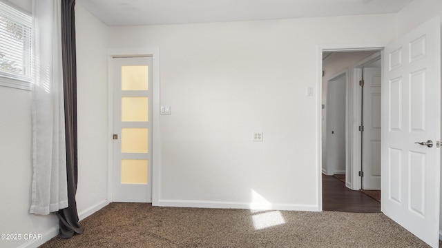 unfurnished bedroom with dark colored carpet