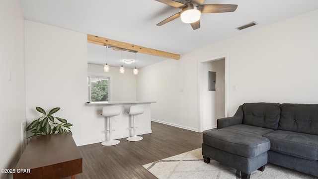 living room featuring rail lighting, dark hardwood / wood-style flooring, electric panel, ceiling fan, and beam ceiling