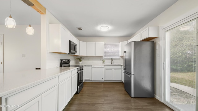 kitchen featuring white cabinetry, stainless steel appliances, sink, and hanging light fixtures