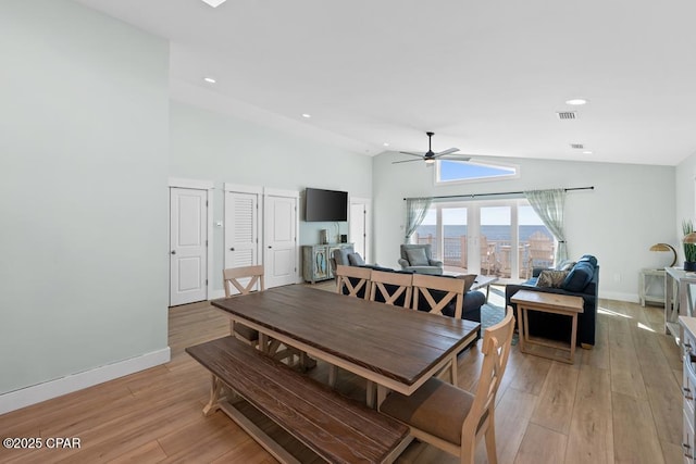 dining space with ceiling fan, lofted ceiling, and light hardwood / wood-style floors