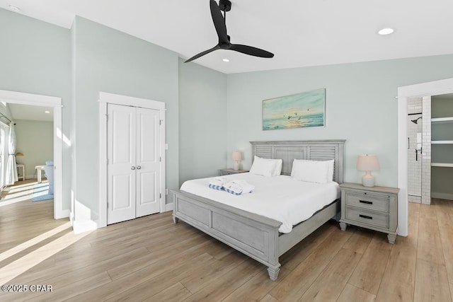 bedroom featuring vaulted ceiling, ceiling fan, a closet, and light wood-type flooring