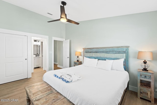 bedroom featuring ceiling fan, ensuite bathroom, and hardwood / wood-style flooring