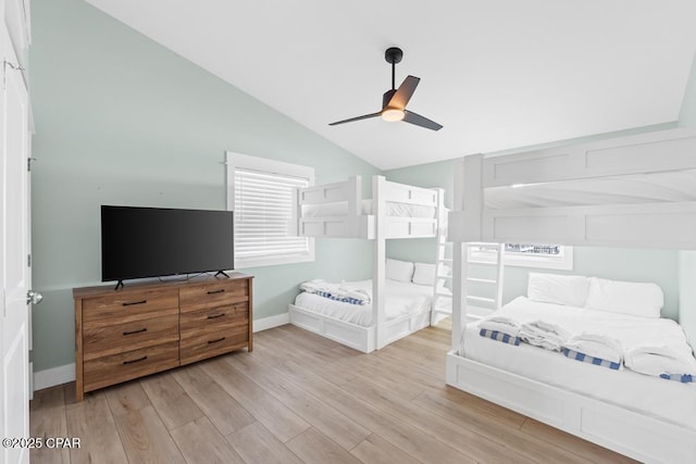 bedroom with ceiling fan, light hardwood / wood-style floors, and vaulted ceiling