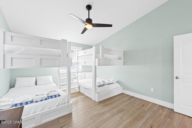 bedroom with ceiling fan, light hardwood / wood-style flooring, and vaulted ceiling