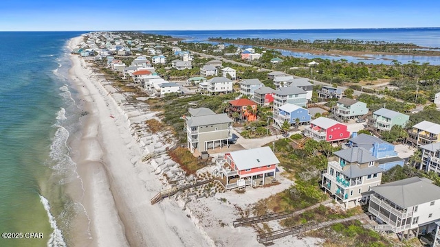 birds eye view of property with a water view and a beach view