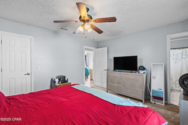 bedroom with carpet floors, a textured ceiling, and ceiling fan