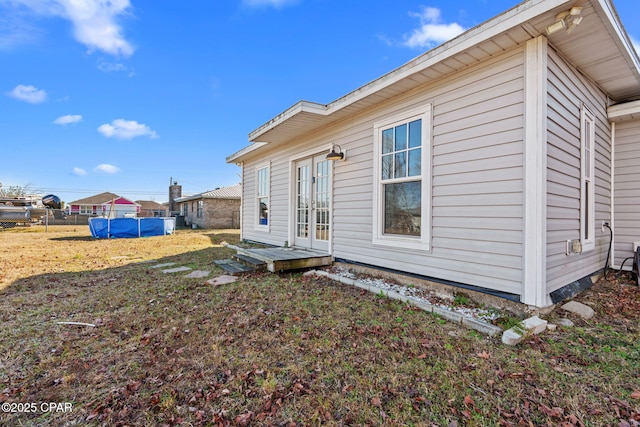 back of property with a swimming pool and french doors