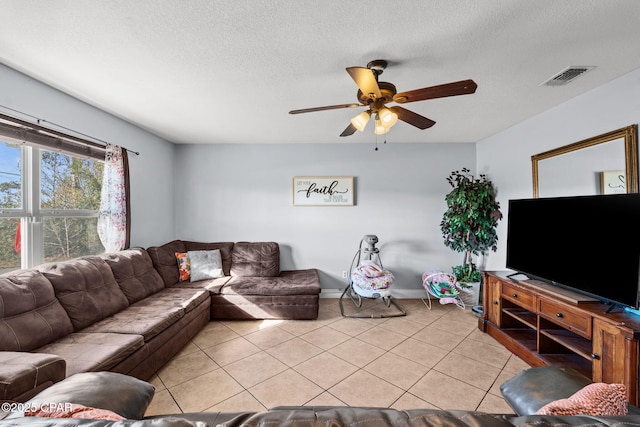 tiled living room featuring ceiling fan and a textured ceiling