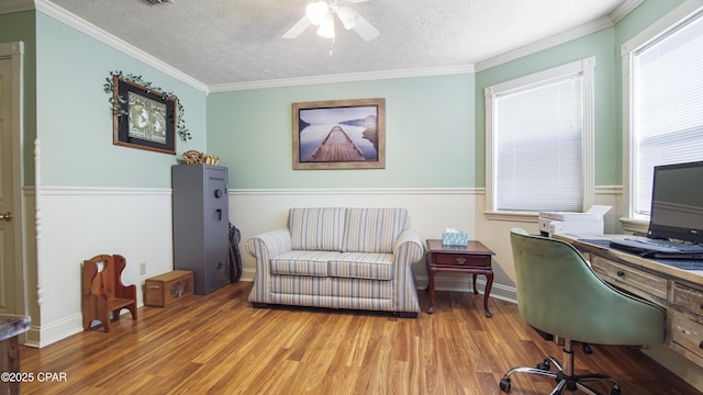 office space featuring light hardwood / wood-style floors, a textured ceiling, crown molding, and ceiling fan