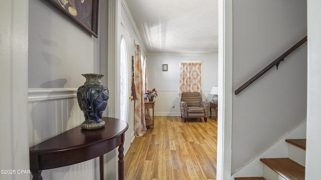 hall with light hardwood / wood-style flooring and ornamental molding