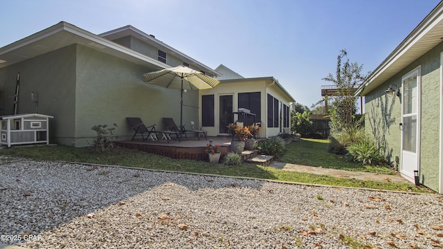 rear view of house with a shed, a yard, and a sunroom