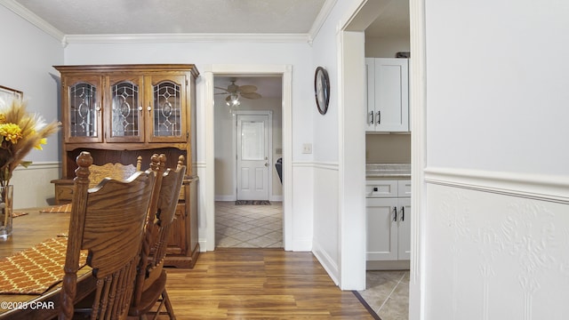 hall featuring a textured ceiling, crown molding, and dark tile patterned floors