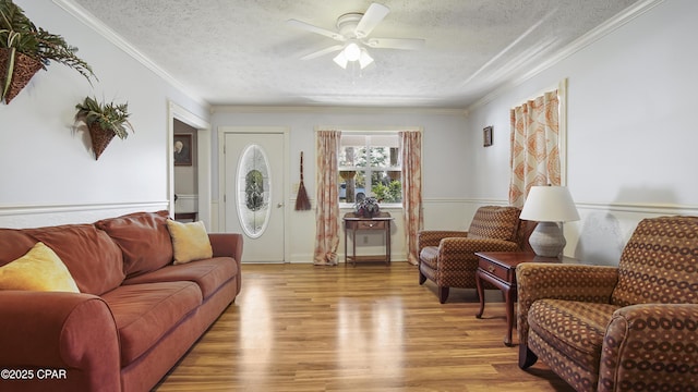 living room with light hardwood / wood-style floors, a textured ceiling, crown molding, and ceiling fan