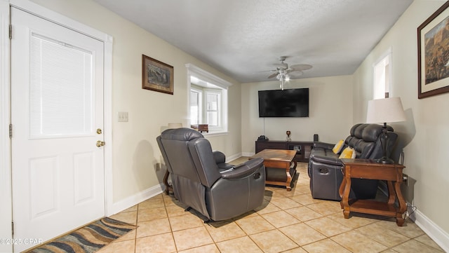 tiled living room featuring ceiling fan and a textured ceiling