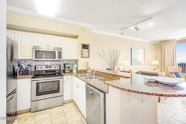 kitchen with sink, stainless steel appliances, kitchen peninsula, and a kitchen bar