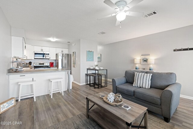 living room featuring ceiling fan and wood-type flooring