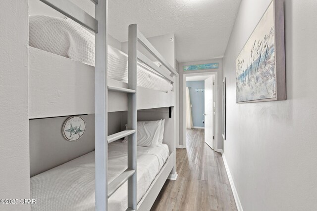 17670 Front Beach Rd Unit I7, Panama City Beach, FL 32413 - bedroom with baseboards, wood finished floors, and a textured ceiling