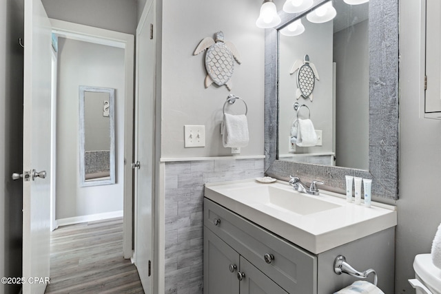 bathroom with vanity, hardwood / wood-style floors, and tile walls