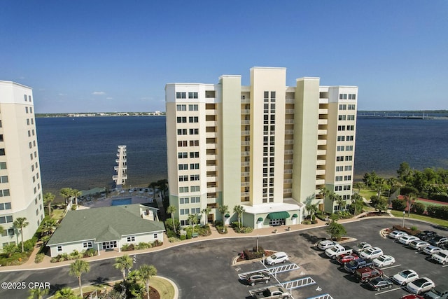 view of building exterior featuring a water view and uncovered parking