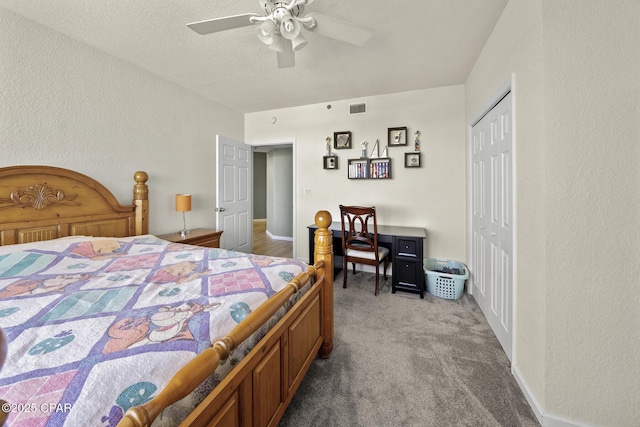 carpeted bedroom featuring visible vents, a closet, ceiling fan, and a textured wall