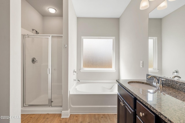 bathroom featuring vanity, hardwood / wood-style flooring, and plus walk in shower