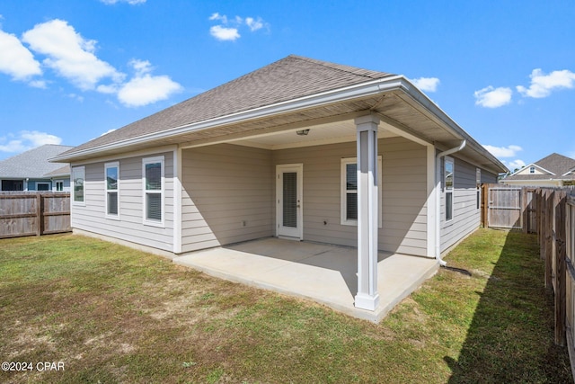 rear view of property with a yard and a patio