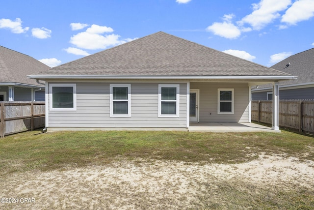 rear view of house with a patio area and a lawn